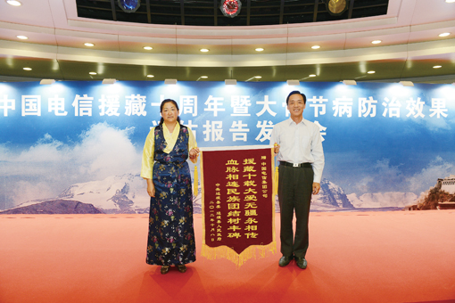 23qyG4b边坝县常委、纪检委书记次仁卓玛向中国电信集团工会常务副主席毛社军赠送锦旗