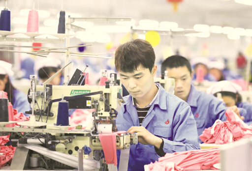 3月2日，两名男缝纫工在山东大型纺织企业即墨市即发集团生产服装产品。