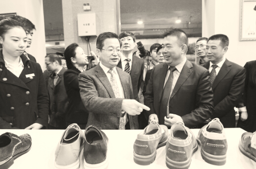 王振滔（右一）为温州市市委书陈一新（左一）介绍奥康布洛克时尚鞋。