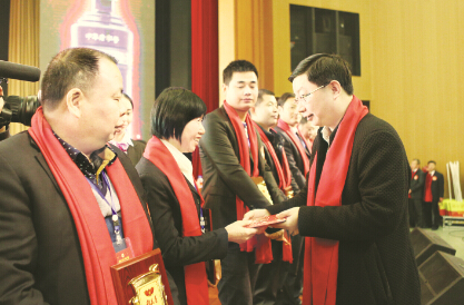 ●在稻花香酒业2015年度总结大会上，蔡开云（右一）为获得最佳贡献奖的经销商颁奖。