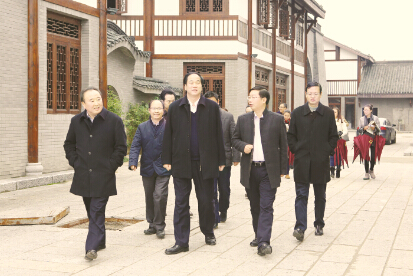 ●蔡开云（前排右二）陪同农业部农产品加工局局长宗锦耀（前排右三）一行参观稻花香集团文化旅游项目——龙泉铺古镇。