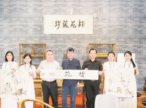 ●田耘（中）向汤雨陶（左三）赠送字画在展区合影。