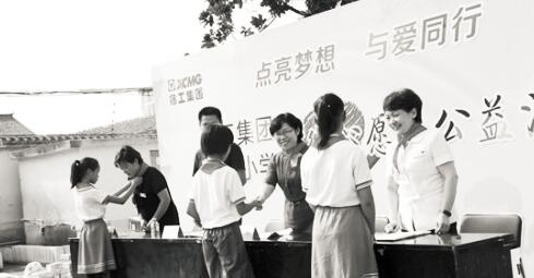 ●徐工希望小学的孩子们替徐工集团的叔叔阿姨们戴上红领巾。