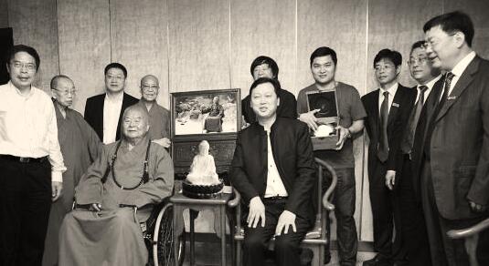 ●滕召华（坐者右）将用大球泥塑造的释迦牟尼佛瓷塑像赠送给星云大师 （坐者左）。 