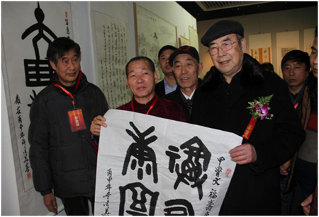 许金美(左2)赠送给中国文联书画艺术中心顾问、中国书协顾问权希军(右1)一幅甲骨文作品“福寿康宁”，并合影留念。
