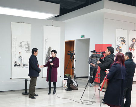 著名人物画家李士良在国家画院国展美术中心“深入生活、扎根人民”优秀人民书画家作品展上接收媒体采访