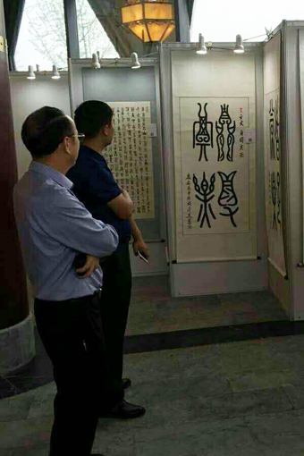 福建泉州市古建公司董事长蒋钦泉和中企报盟信息科学研究院秘书长薛雷在许金美作品前讨论