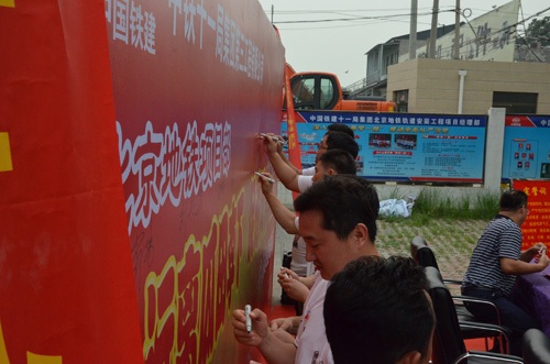 在展板上签字表决心